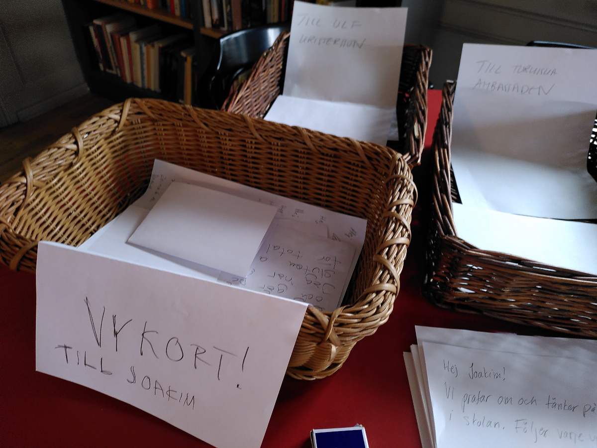 Korgar med papper i. Närmaste korgen har texten "Vykort till Joakim"